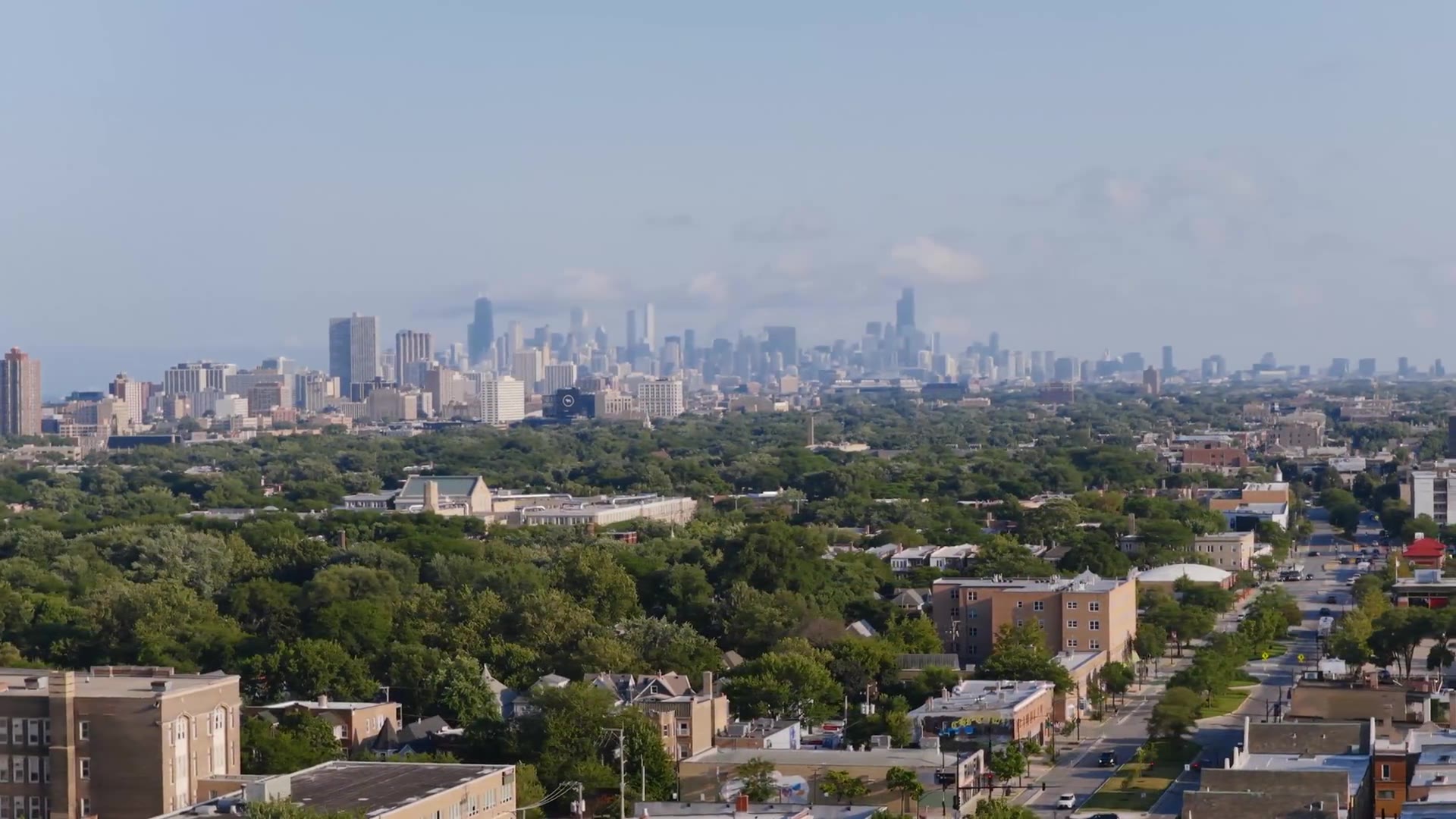 Aerial view across Chicago neighborhoods toward the downtown skyline